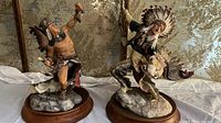 Pair of Native American Indian statues on wooden bases, showing detailed costumes and lifelike poses.