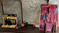 DeWalt battery and charger packaging, Black & Decker LED light in front of wall