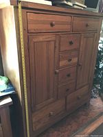 Front view of closed armoire showing drawers, doors, and overall form