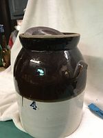 Front view of a vintage two-tone stoneware crock with lid, marked number 4 indicating 4-gallon capacity.
