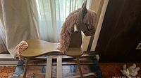 Vintage wooden hobby horse on rocker base near window with curtain background