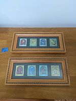 Two wooden framed collections of four colorful Israeli stamps each, displayed on a wood surface.