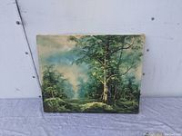 Front view of oil painting showing nature scene with trees and foggy background.