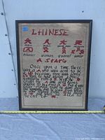 Framed art piece showing Chinese characters and English handwritten story text with translations.
