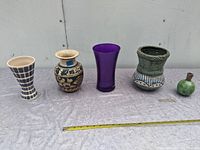Photo showing the five vintage decorative vases arranged on a table with measuring tape in front.