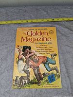 Front cover view of one Golden Magazine issue showing cover story and size measurement tape