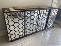 Front view of entire cabinet showing four honeycomb-pattern mirrored doors