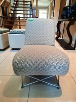 Front view of the upholstered accent chair showing pattern and metal leg structure.