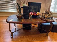 Full view of rectangular coffee table with wood frame, stone tile top, and metal legs. Table top holds decorative items not included.
