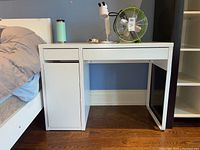 Front view of entire desk showing overall structure: two top drawers, left cabinet door, right open cubby.
