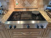 Front perspective showing stainless steel control panel and four-burner cooktop