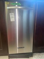 Front view of stainless steel compactor installed in cabinetry