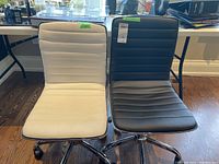Front view of white and black chairs side by side on wooden floor