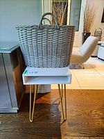 Side table displayed with gray woven basket on top, showing overall size and design.