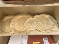 Five capiz shell plates grouped together showing various sizes.