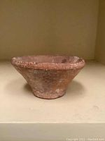 Photo showing top and side view of old ceramic bowl with rough texture and rustic color.