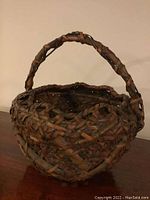 Front-side angle view of the handwoven basket showing handle and weave details