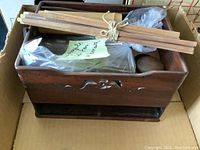 Top view of the wood desk set showing tied wooden sticks, bamboo tube, small wooden compartment, and other wooden parts inside a box.