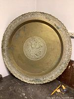 Full view of round Moroccan brass tray with scalloped edge and patina.