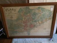 Full view of 1872 map of Manila in wooden frame showing city layout and boundaries in varied colors.