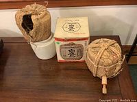 Overview of two sake kegs and one box on wooden surface