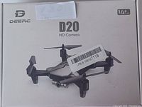 Box front of Deerc D20 HD Camera drone showing brand and age recommendation 14+. Grey and black drone pictured on box.