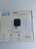 Front view of the original retail box of Blink Mini indoor smart security camera showing product image and main features like day & night HD video, two-way audio, motion detection, and Alexa compatibility.
