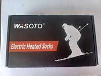Front of box showing Wasoto brand and Electric Heated Socks labeling with skiing graphic.