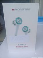 Front view of the white box showing Monster logo and image of white earbuds with green accent, model name Clarity 102 Airlinks.