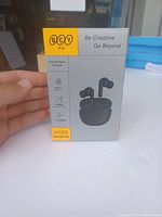 Front of the QCY wireless earbuds box showing product image, brand and some feature icons.