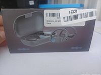 Box showing image of black wireless earbuds and open charging case on front.