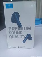 Front of retail box showing blue Haylou W1 true wireless earbuds and key features highlighting premium sound quality.