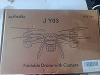 Zuhafa J Y03 drone in original cardboard box with foldable drone illustrated on the front, labeled for age 14+.