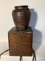 Full view of Bizen Ware jar sitting on the wooden storage box, showing scale and overall appearance.