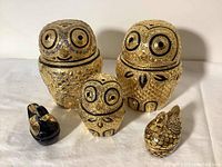 Five lacquered owl and duck-shaped trinket boxes arranged side by side showing front views, highlighting size and detail differences.