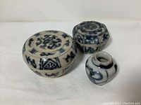 Top and side view of the three ceramic pots showing colorful blue and white designs and varying sizes.