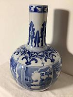 Full view of ceramic vase displaying the neck and body decorations with figurative scenes.