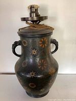 Full view of the cloisonné urn with floral design and two dragon-head handles, lamp assembly on top with vintage electrical cord visible.