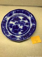 Single scalloped edge plate with Flow Blue blue and white Chinese landscape pattern