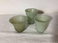 Side view of three jade cups showing shape and relative sizes