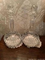 Pair of crystal decanters side by side, showing overall shape and stoppers.