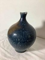 Front and side view of glazed stoneware bud vase showing color, shape, and texture