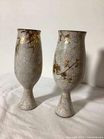 Front and side view of the pair of lacquered goblets showing botanical designs and crackled finish.