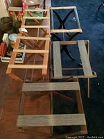 Overview of six wooden luggage racks with fabric straps in natural and dark wood tones, foldable X-frame design.