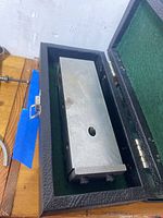 Machinist tooling fixture resting inside its protective black leatherette case.