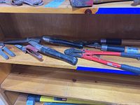 Photo showing 5 cutting tools including loppers, shears, and hand cutters with metal and wooden handles