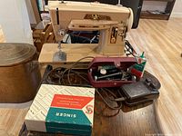Full view of vintage Singer 403A sewing machine on wood surface with foot pedal, oil can, and accessory box.