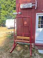 Full view of red ski lift bench against exterior wall