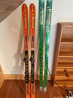 Volki and Rossignol skis standing upright against a wall showcasing color and bindings