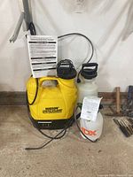 Full view of the three sprayers lined up against wall, showing their size and design differences.